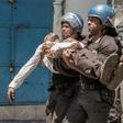 Police take away a plainclothes policeman injured in Monday's clashes