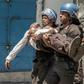 Police take away a plainclothes policeman injured in Monday's clashes