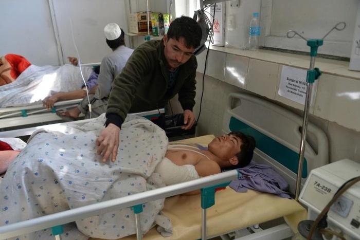 Afghan victims receive medical treatment at a hospital following a suicide attack on a private construction company in Jalalabad