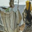 A woman carries a container of water at a UN-protected site in Juba that offers shelter to civilians fleeing fighting