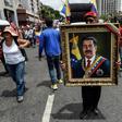 A painting depicting Venezuelan President Nicolas Maduro is displayed by a supporter during a pro-government demonstration in Caracas