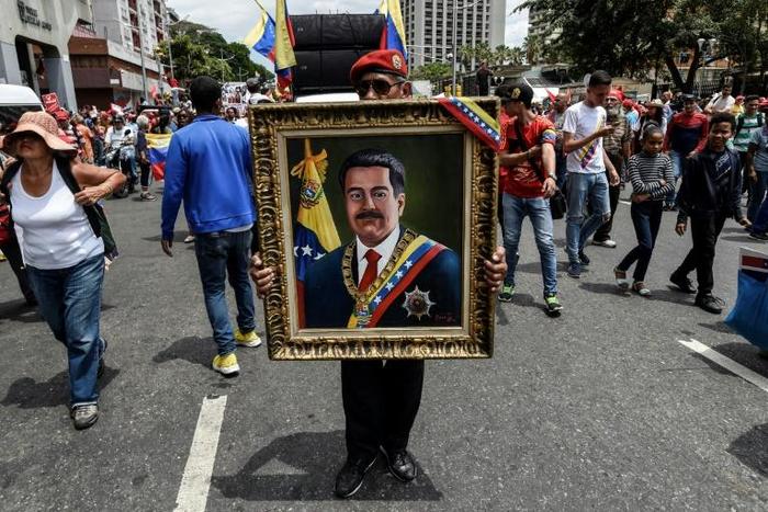 A painting depicting Venezuelan President Nicolas Maduro is displayed by a supporter during a pro-government demonstration in Caracas