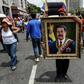 A painting depicting Venezuelan President Nicolas Maduro is displayed by a supporter during a pro-government demonstration in Caracas