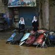 Pedestrians look for dry ground on a street after heavy rains in Kabul