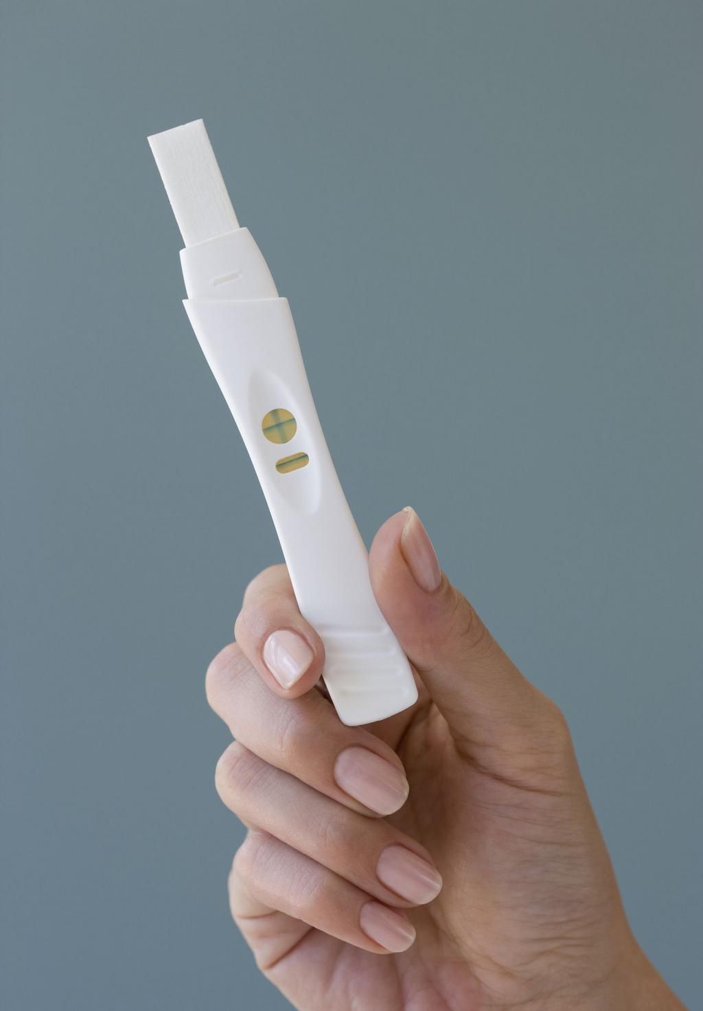Close up of woman holding pregnancy test