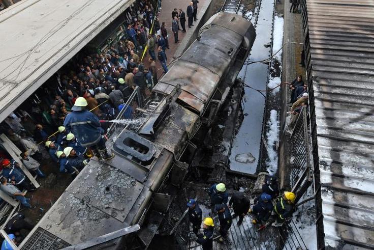 Firefighters and onlookers at the scene of a train crash in Cairo's main rail station last month