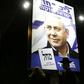 A woman and an ultra-Orthodox Jewish man walk past a billboard displaying Israeli Prime Minister Benjamin Netanyahu in Jerusalem