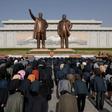 People pay their respects before the statues of late North Korean leaders Kim Il Sung and Kim Jong Il