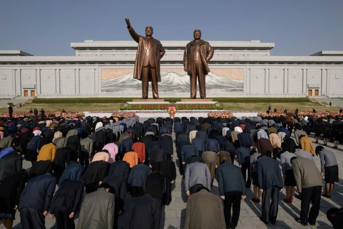 People pay their respects before the statues of late North Korean leaders Kim Il Sung and Kim Jong Il