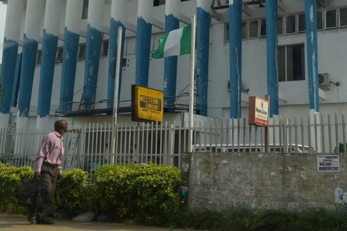 A man walk past a Western Union money transfer and Moneygram in Benin City, Nigeria