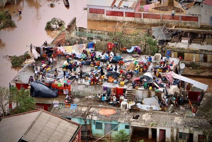 Survivors seek safety on the roof of a house submerged by floods in Mozambique's Buzi town