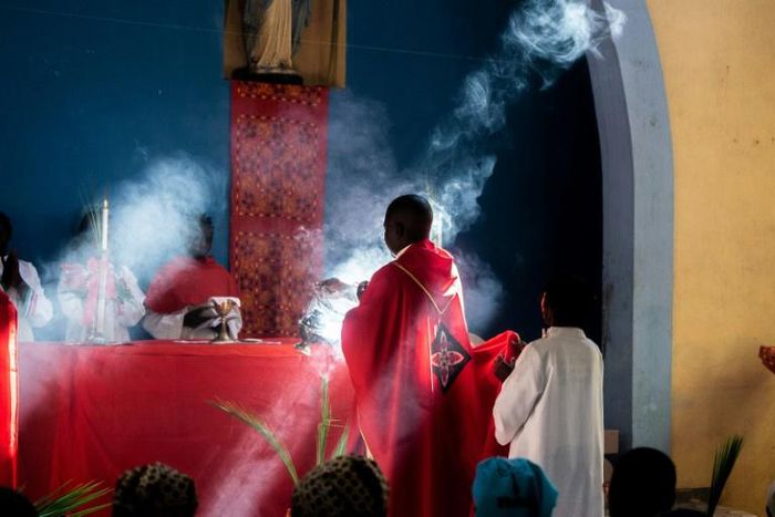 Father Celso Taibo burns incense during a palm Sunday mass in Buzi