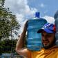 A man carries drums with water he collected from a stream at the Wuaraira Repano mountain, also called El Avila, in Caracas on March 13, 2019