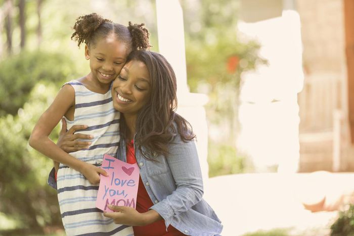Happy Mother's Day Girl gives card to mother