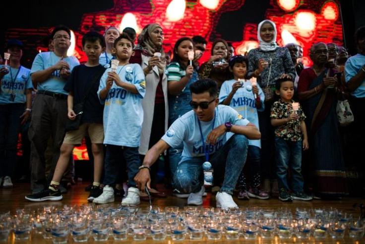 Hundreds of people, including some of the relatives of those onboard, gathered at a Kuala Lumpur shopping mall Sunday to mark the anniversary of the jet's disappearance
