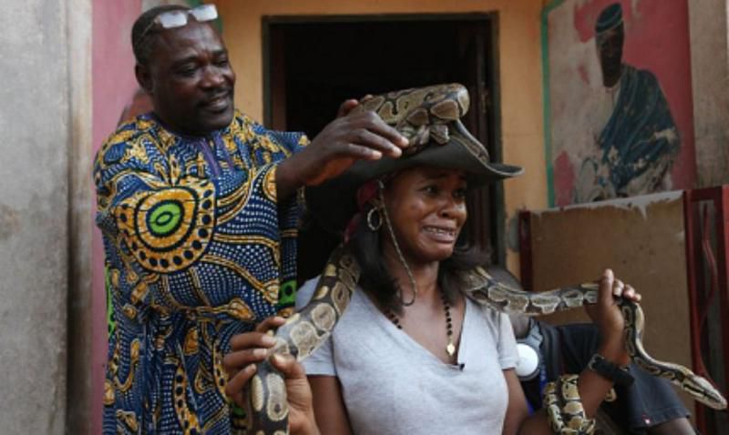 A tourist carrying a snake at Temple des pythons [Black feelings]