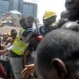 Survivor: Emergency workers pluck a child from the collapsed building. The disaster left 20 dead, according to a new toll