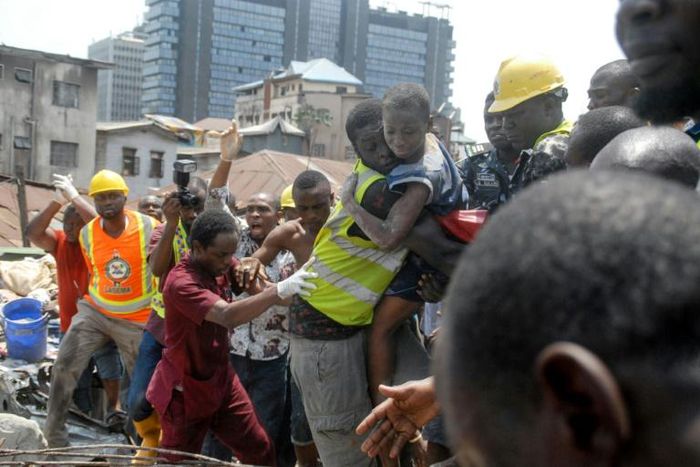 Survivor: Emergency workers pluck a child from the collapsed building. The disaster left 20 dead, according to a new toll