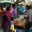 An Indian election official explains the procedure to cast a ballot to voters at a tea estate near Siliguri, West Bengal