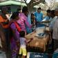 An Indian election official explains the procedure to cast a ballot to voters at a tea estate near Siliguri, West Bengal