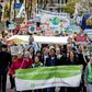 Dozens of activists march toward Shell's base in The Hague, where they will deliver a legal summons with a court date set for April 17, 2019