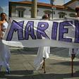 Women walk on stilts while holding a banner in memory of Rio councillor Marielle Franco, at the location in Rio de Janeiro where she was shot dead