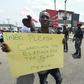 A protester holds a placard reading "Please conclude the elections for the sake of peace" during a demonstration against the suspension of governorship elections in Port Harcourt, Rivers state