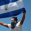 An opposition protester displays a Nicaraguan flag at a mall where he and others took refuge after they were prevented by riot police in Managua from demonstrating against the government to demand the release of those arrested for taking part in anti-g...