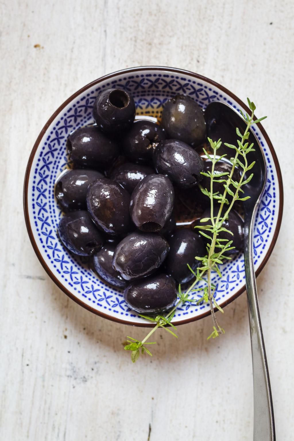 Black olives in bowl with thyme