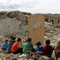 Children watch a puppet show in the ruins of the town of Saraqib in Syria's jihadist-held Idlib region where renewed fighting threatens to flare