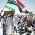 Sudanese men attend Friday prayers as they determine to keep up a week-long protest outside the Khartoum army headquarters