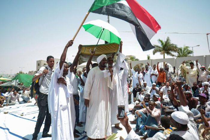 Sudanese men attend Friday prayers as they determine to keep up a week-long protest outside the Khartoum army headquarters