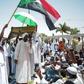 Sudanese men attend Friday prayers as they determine to keep up a week-long protest outside the Khartoum army headquarters