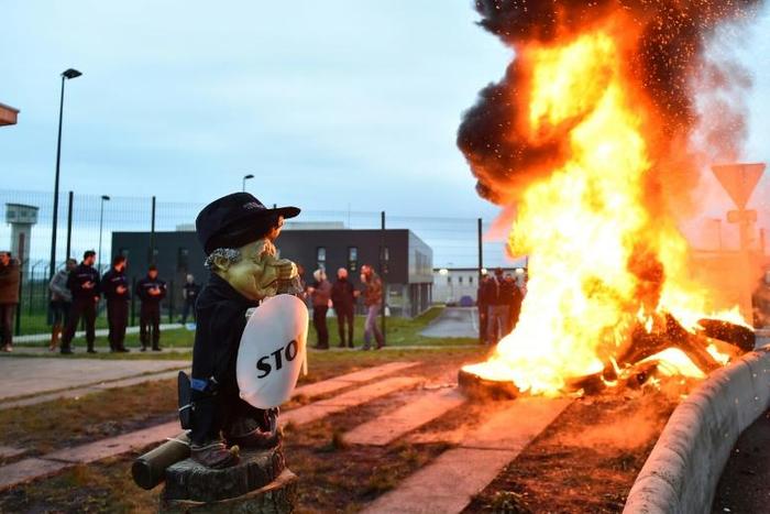 The guards set fires outside the high-security facility at Conde-sur-Sarthe in Normandy