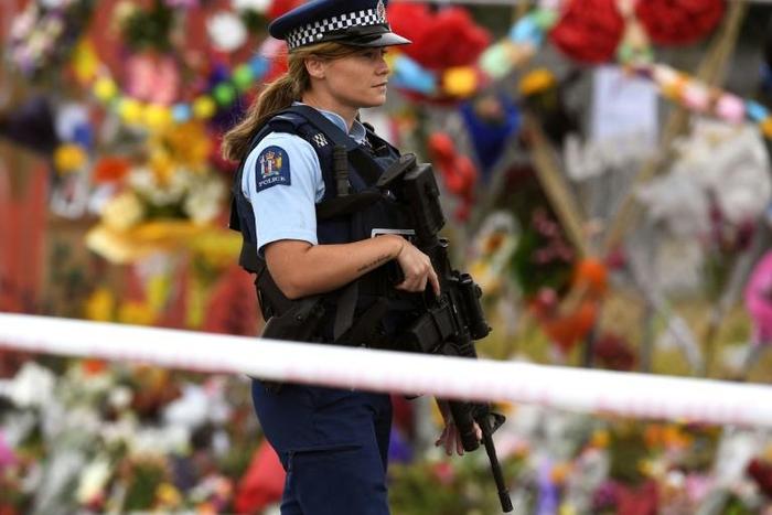 A policewoman patrols past a memorial wall outside the Linwood Mosque in Christchurch on Thursday