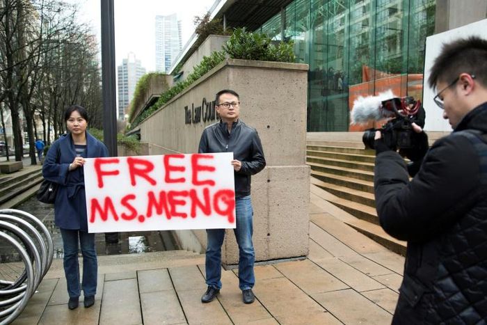 Two demonstrators outside a courthouse in Vancouver on December 10, 2018 call for the release of Huawei executive Meng Wanzhou after she was detained for possible extradition to the US for alleged sanctions busting
