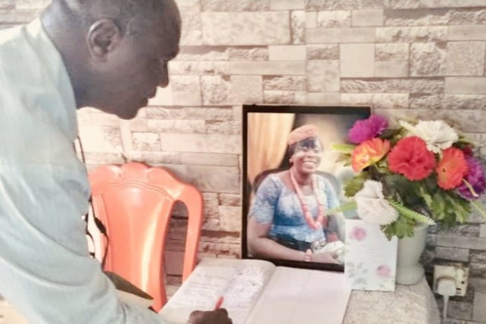 A member of INEC delegation signing the condolence register at the residence of late Miss Ibisaki Amachree. (Punch)