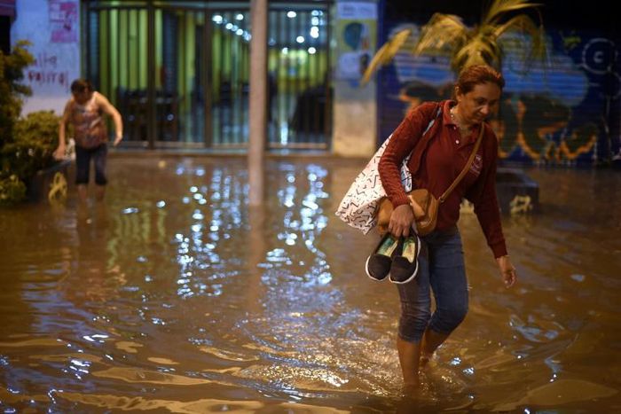 A Brazilian woman walks barefoot through floods in Rio de Janeiro -- in Sao Paulo, heavy rains triggered floods that left seven people dead