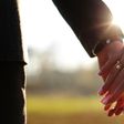 Wedding couple holding hands on sunset background shot in slow motion (Shutterstock)