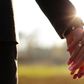 Wedding couple holding hands on sunset background shot in slow motion (Shutterstock)