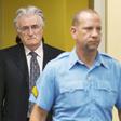 Bosnian Serb wartime leader Radovan Karadzic (left) is led into the courthouse during a 2013 appearance at the International Criminal Tribunal for Former Yugoslavia (ICTY) in The Hague