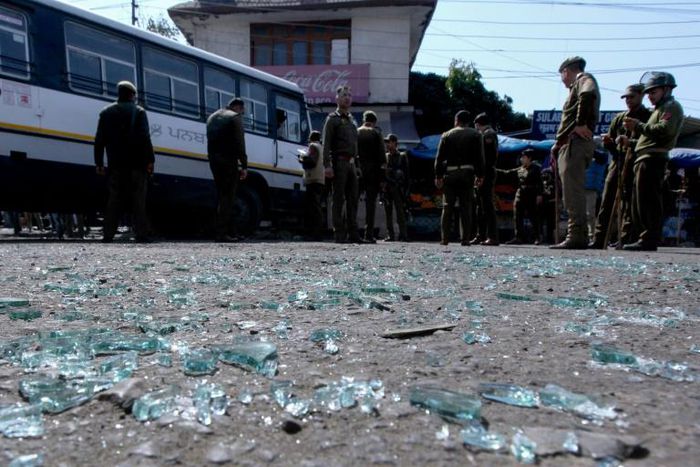 Indian police inspect the site of a grenade blast at a bus station in Jammu