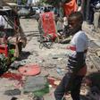 A Somali boy walks near blood-stains and debris on the ground after an explosion outside a restaurant in Mogadishu that left at least 15 people dead