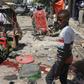 A Somali boy walks near blood-stains and debris on the ground after an explosion outside a restaurant in Mogadishu that left at least 15 people dead