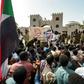 Protesters gather in front of soldiers during a rally demanding a civilian body to lead the transition to democracy, outside the army headquarters in the Sudanese capital Khartoum on April 12, 2019