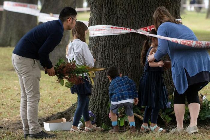 New Zealanders lay flowers near one of the mosques targeted in Friday's deadly attack