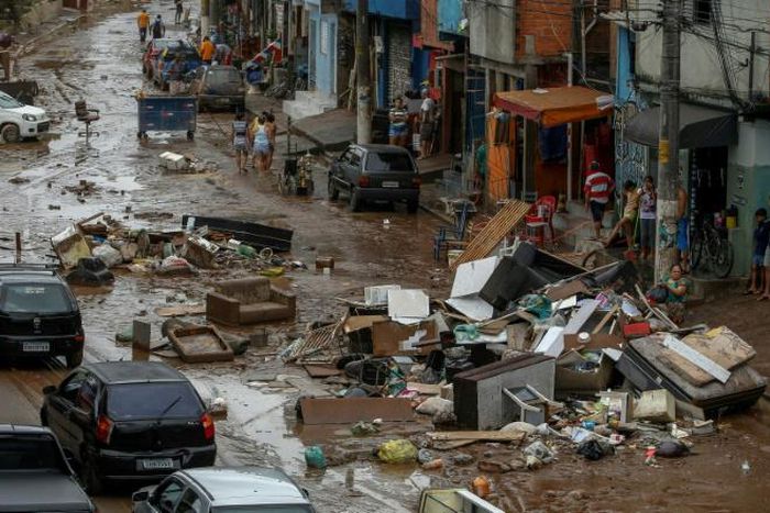 The unusually heavy rain that struck the Rio de Janeiro region triggered flash flooding that turned some streets into raging rivers, gushing through ground-level homes and businesses and weakening structures