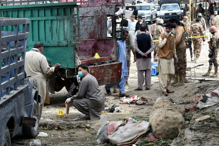 Pakistani security officials inspect the site of a bomb blast at a fruit market in Quetta