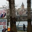 People walk past election banners of Turkish President Tayyip Erdogan and AK Party's mayoral candidate for Istanbul, Binali Yildirim, in Istanbul