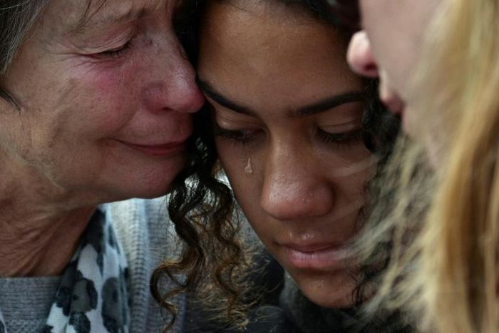 Residents shed tears after leaving flowers in tribute to victims of the New Zealand massacre, two days after a mass shooting at two mosques in the southern city of Christchurch